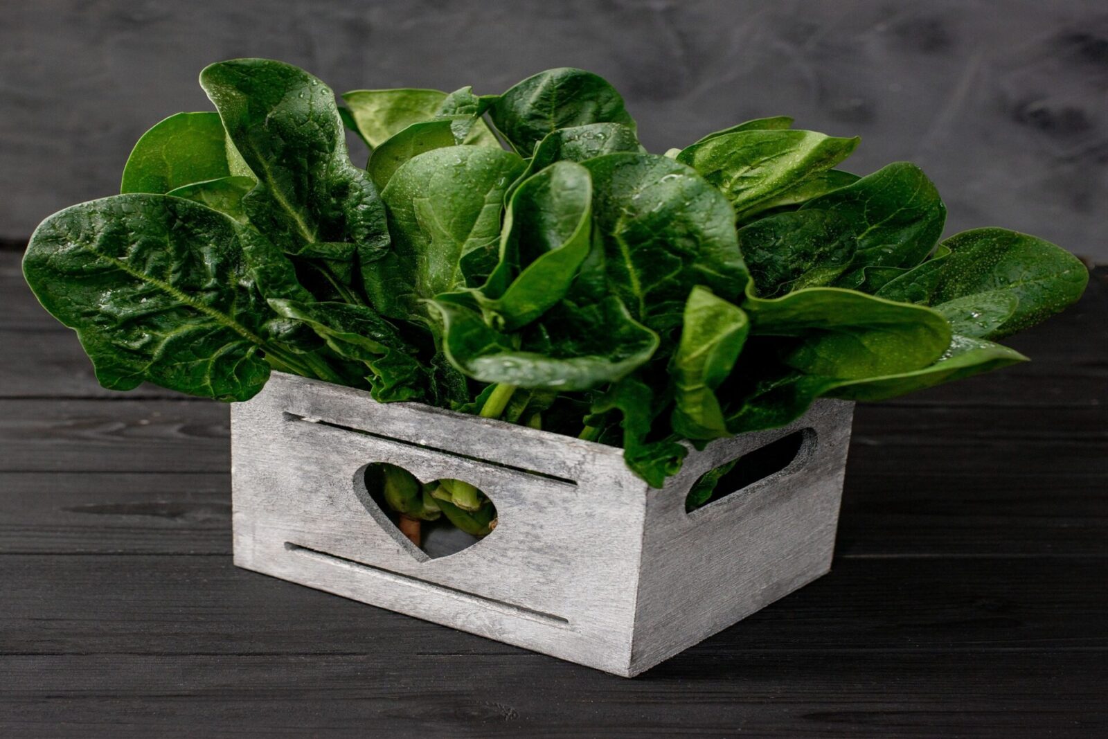 clean food concept leaves fresh organic spinach greens wooden box black background healthy detox spring summer diet vegan raw food