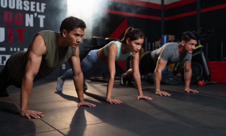 diverse group fit men woman sportswear exercise pushups floor fitness gym