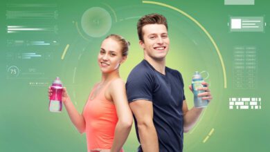 sport fitness technology people concept happy sportive man woman with water bottles green background