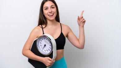 young girl isolated white background with weighing machine