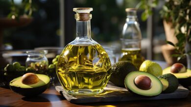 Avocado oil on a table in a glass bottle on a background of greenery Generative AI