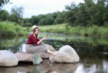 beautiful young girl nature by river with fishing rod