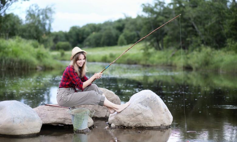 beautiful young girl nature by river with fishing rod