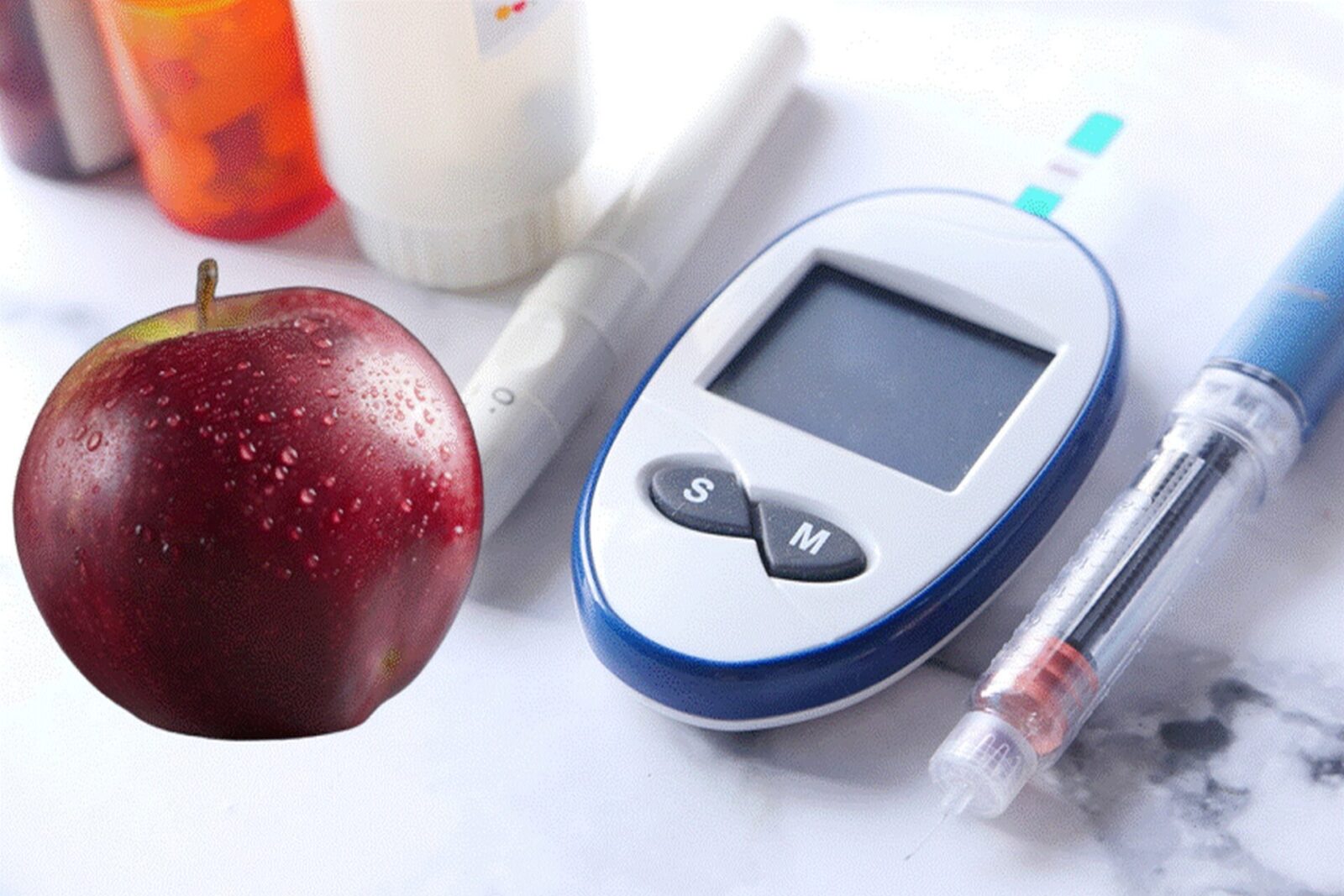 Apple next to glucose meter and insulin pen illustrating the connection between apples and diabetes management