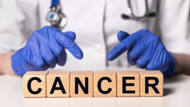 Female doctor holding wooden dices with the word 'cancer' for a comprehensive cancer guide article