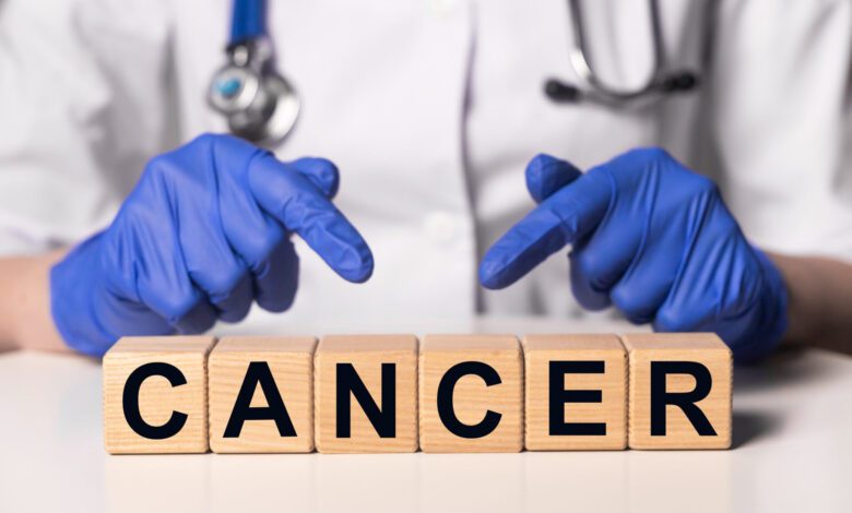 Female doctor holding wooden dices with the word 'cancer' for a comprehensive cancer guide article