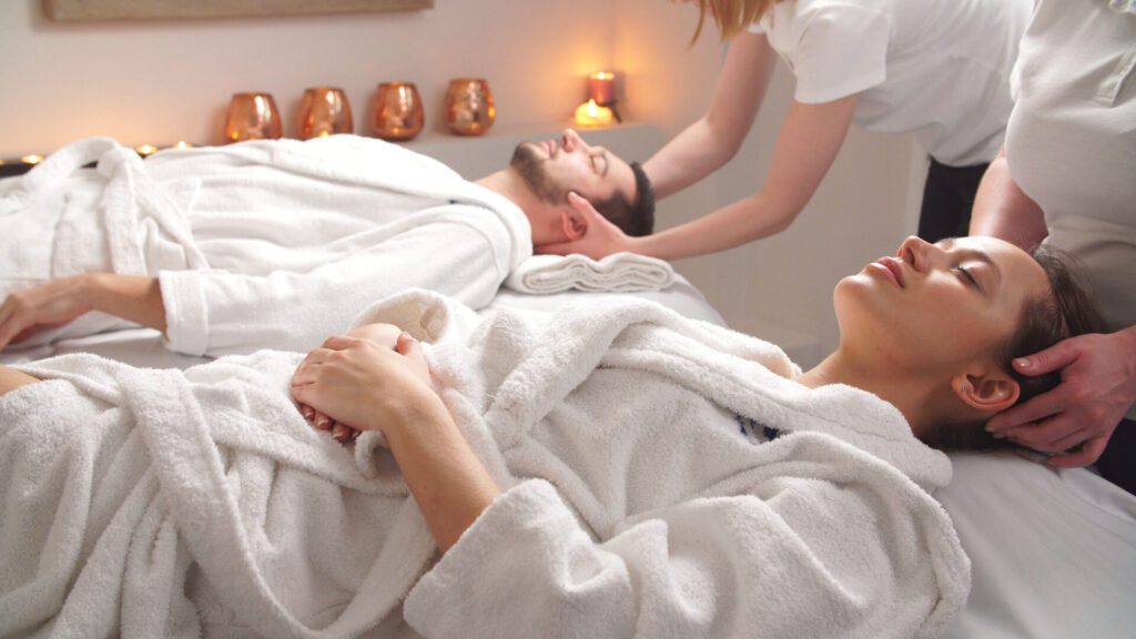 beautiful couple lying down massage beds enjoying head massage luxury spa