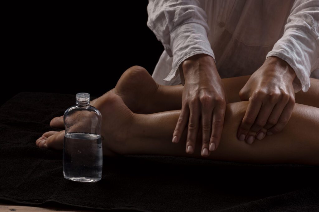 a girl makes a massage with oil close up on a dark background