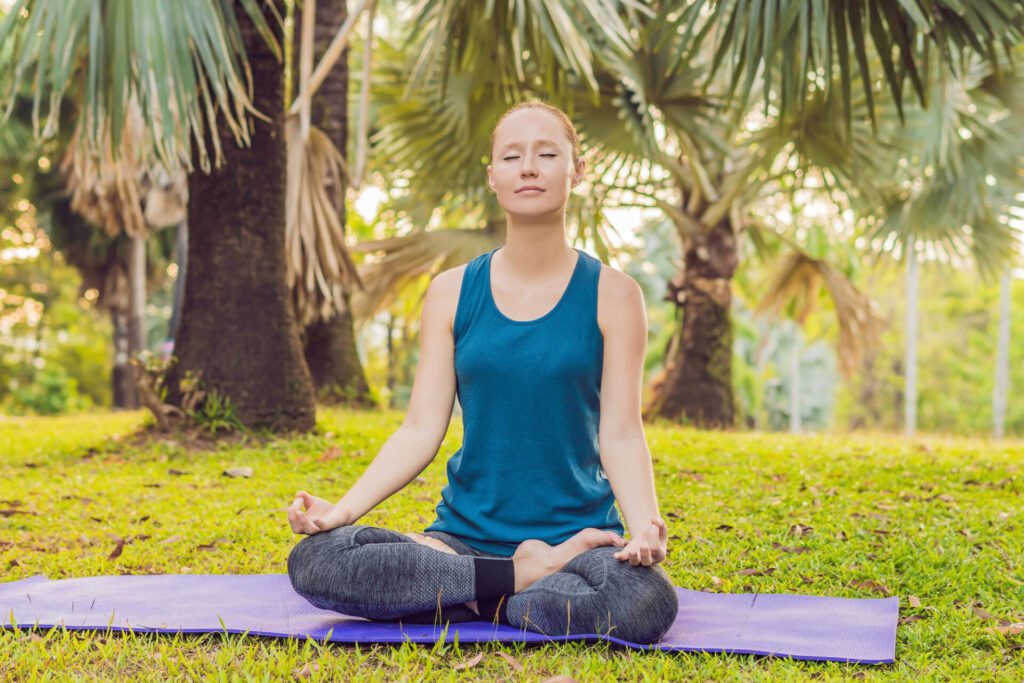 woman practicing yoga tropical park
