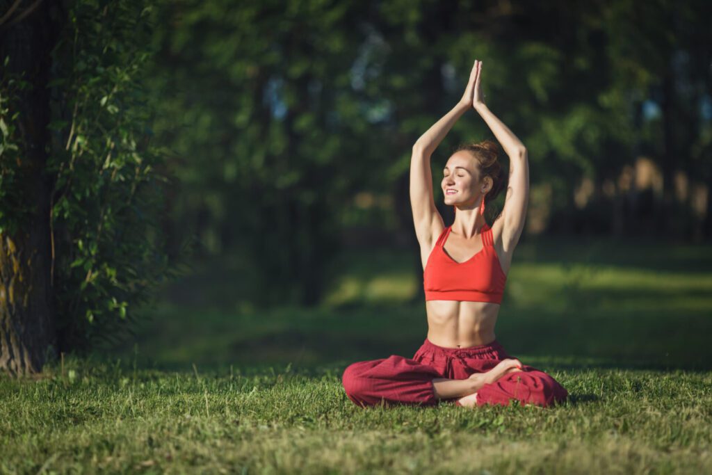 young woman practicing yoga outdoors female meditate outdoor summer city park