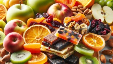An artistic arrangement of healthy fruit snacks, including fresh fruit slices like apples, oranges, and kiwis, dried fruits such as apricots and cranb
